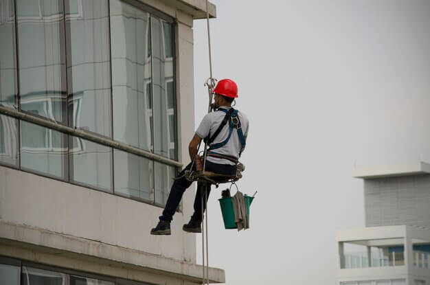 A VertiGleam technician safely working on a high-rise building